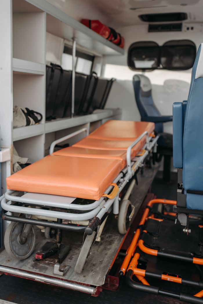 hero-img-01 Detailed view inside an ambulance showing stretcher and medical equipment storage.